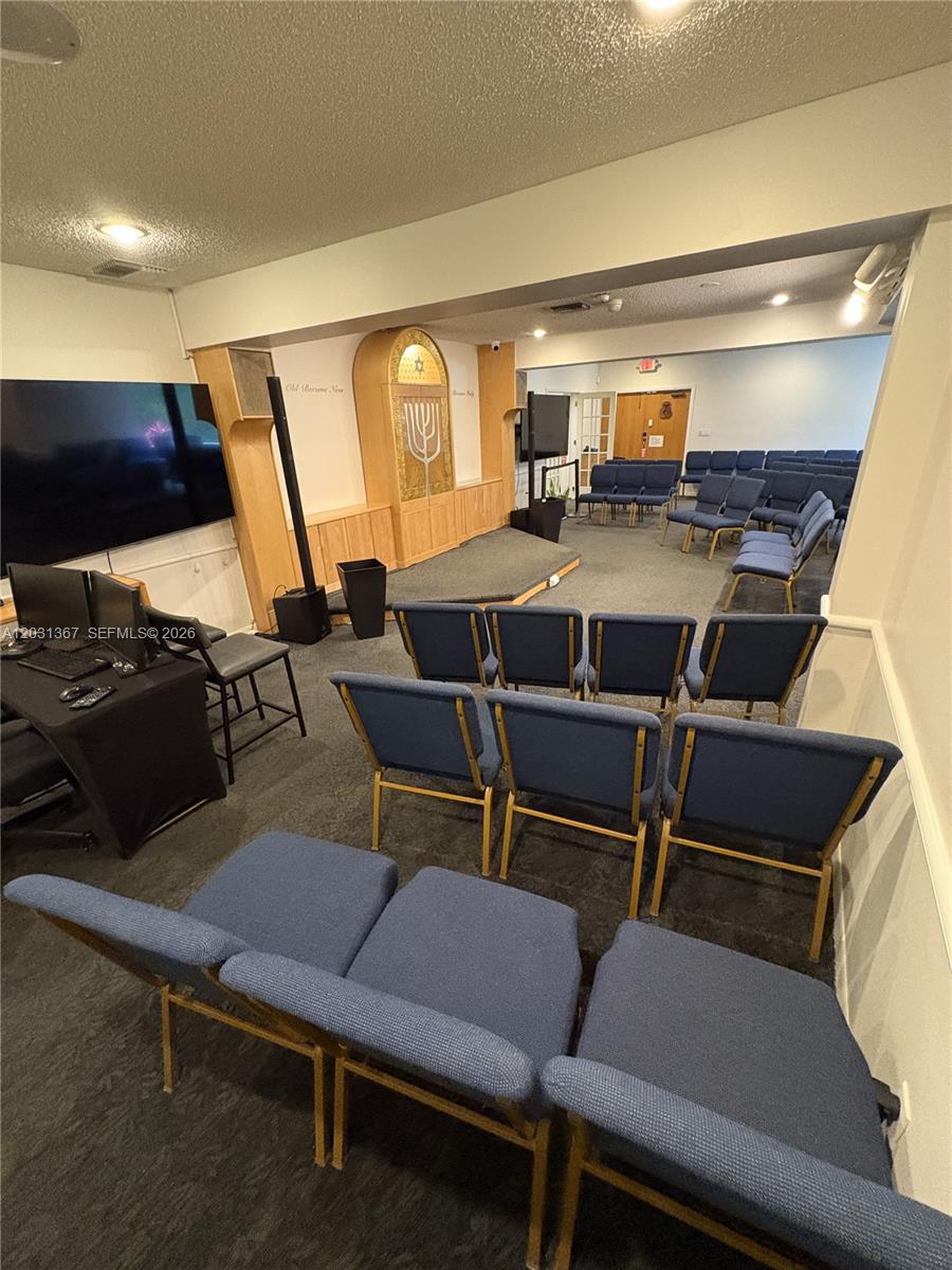 A small synagogue sanctuary features rows of blue chairs facing a wooden ark — 11715 SW 87th Ave, Miami FL 33176, MIAMI, FL