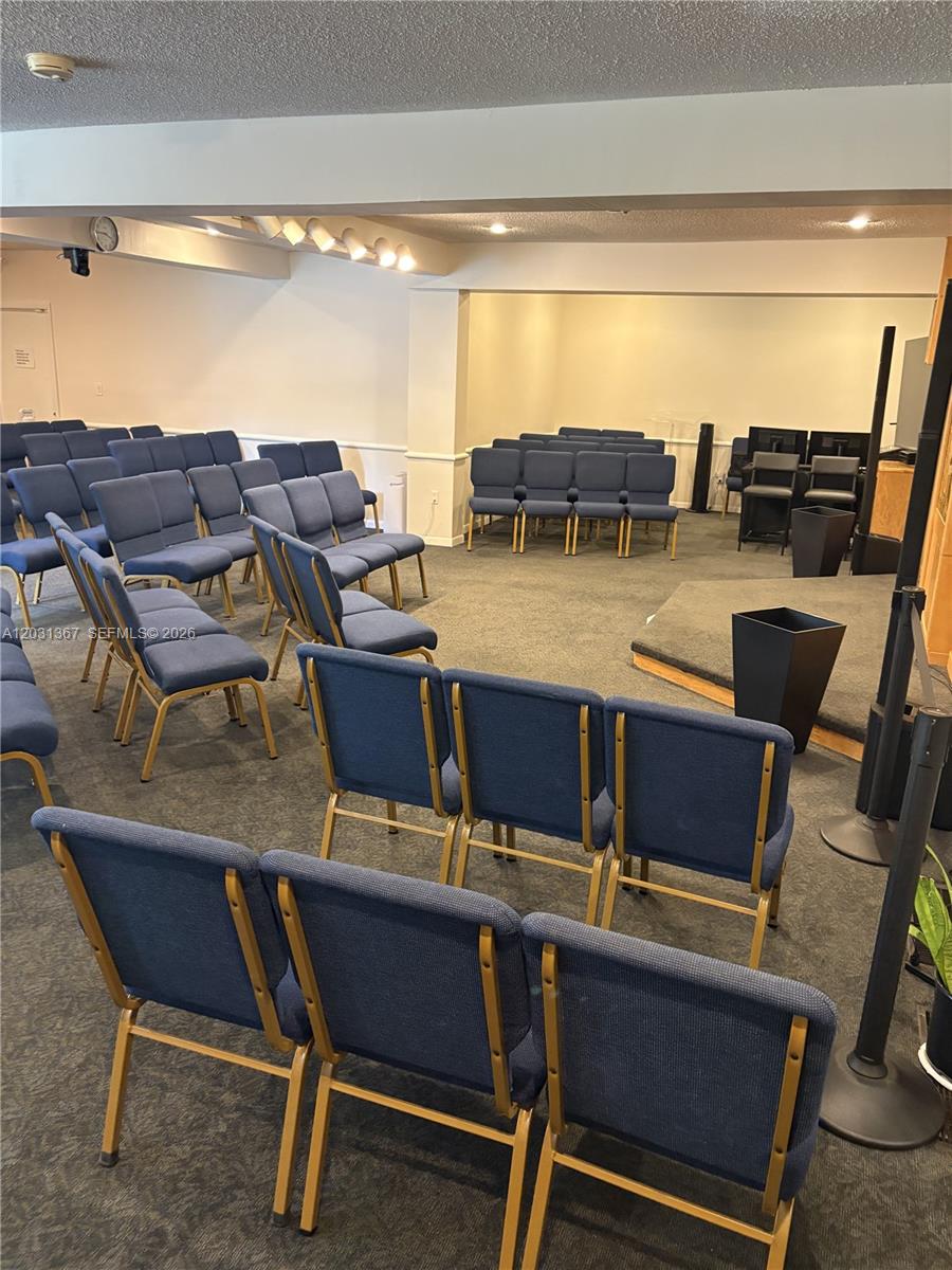 A room with rows of blue chairs facing a small stage and podium — 11715 SW 87th Ave, Miami FL 33176, MIAMI, FL