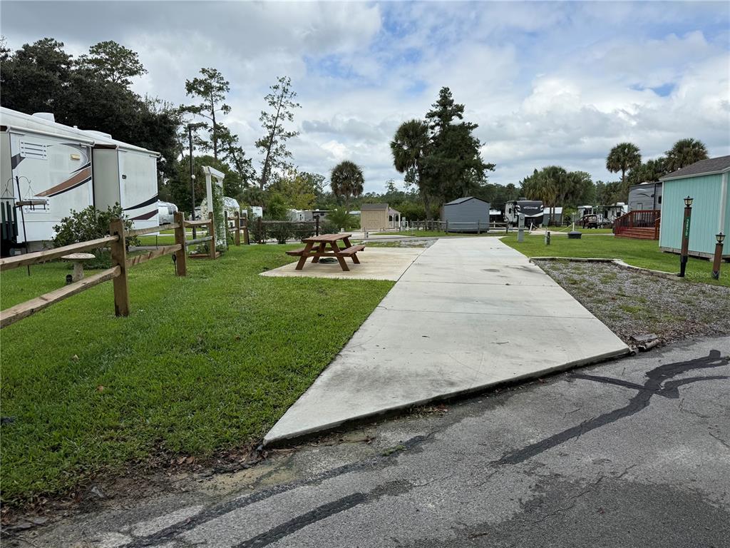A concrete driveway leads to a picnic table on a patio in an RV park — 2870 NE 103RD AVENUE, SILVER SPRINGS, FL