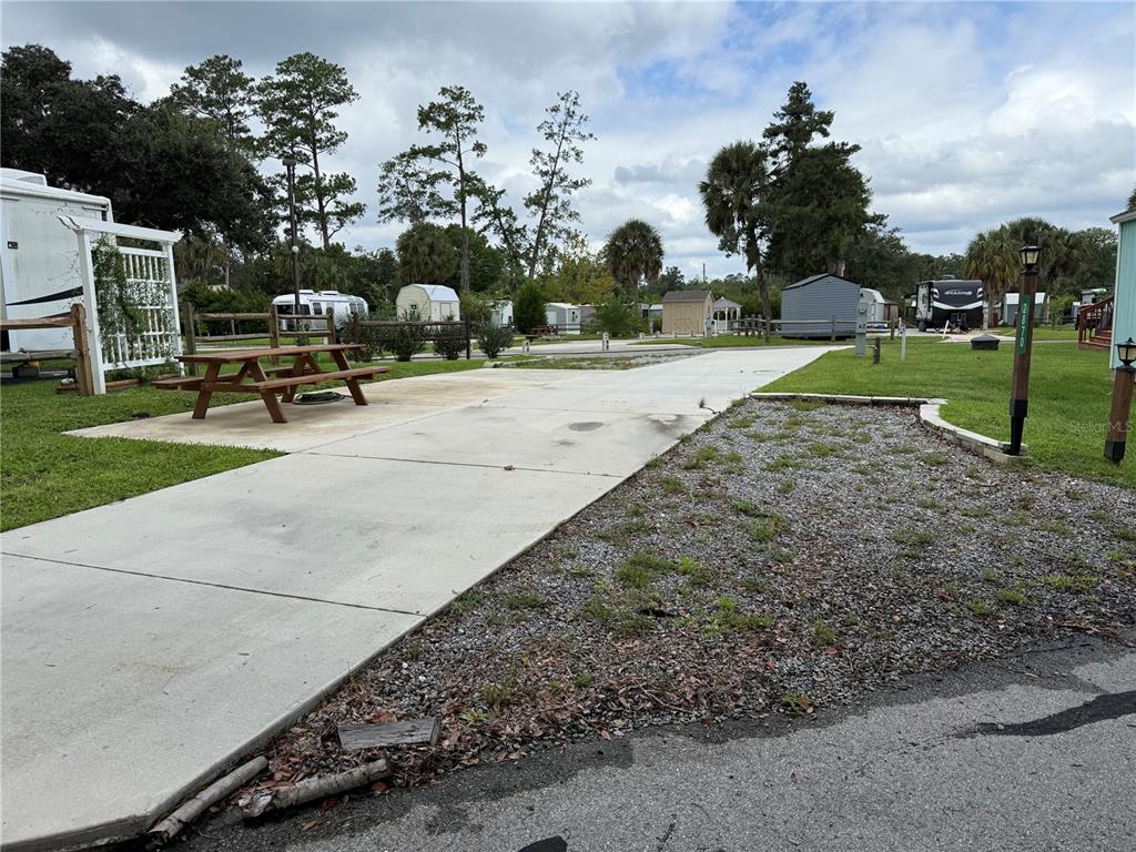 A concrete RV pad features a wooden picnic table and gravel landscaping in a park — 2870 NE 103RD AVENUE, SILVER SPRINGS, FL