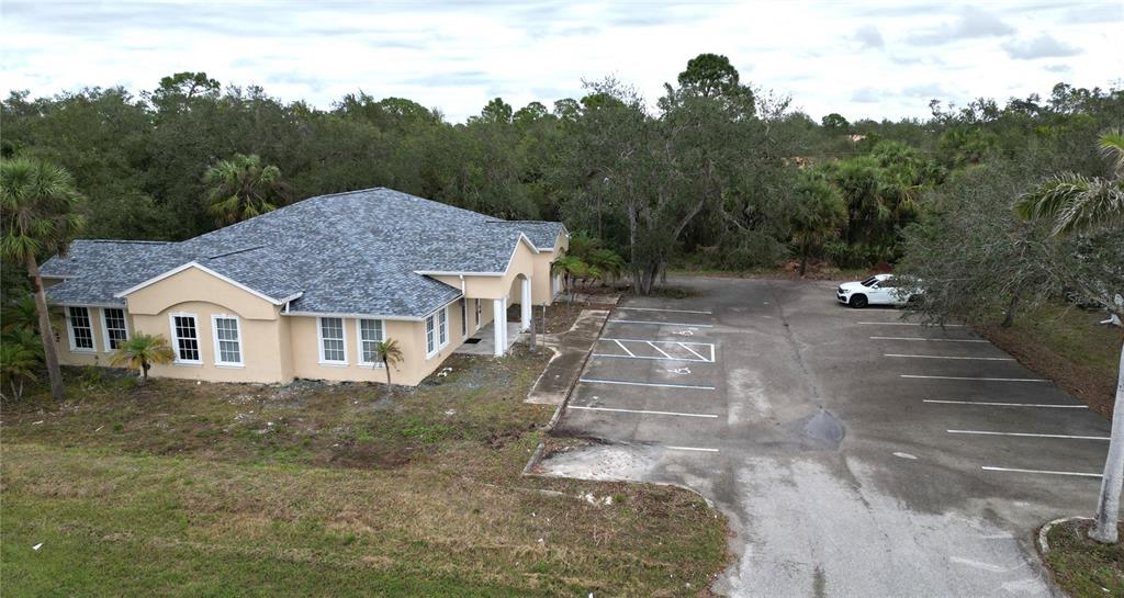 An aerial view of a single-story tan building with a gray roof and adjacent parking lot — 17880 TOLEDO BLADE BOULEVARD, PORT CHARLOTTE, FL
