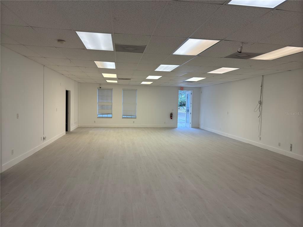 An empty commercial space features white walls, light wood-look flooring, and a drop ceiling — 17880 TOLEDO BLADE BOULEVARD, PORT CHARLOTTE, FL