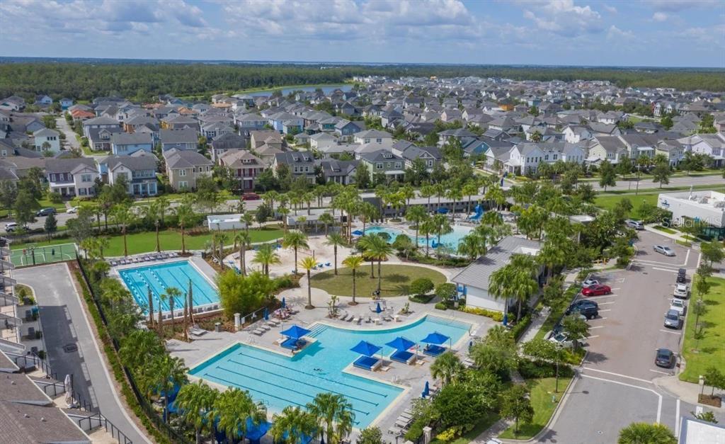 An aerial view of a community swimming pool complex surrounded by houses and palm trees — 10016 PEEBLES STREET, ORLANDO, FL