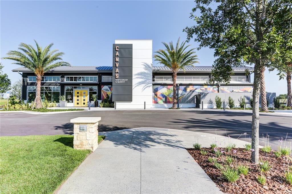 The exterior of a modern commercial building features a central sign, palm trees, and landscaping — 10016 PEEBLES STREET, ORLANDO, FL