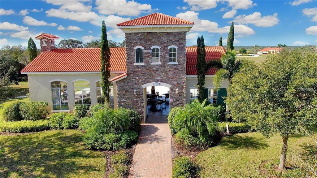 A stone-facade clubhouse with a red tile roof and a brick walkway entrance — 5234 LAKE VENICE DRIVE, WIMAUMA, FL