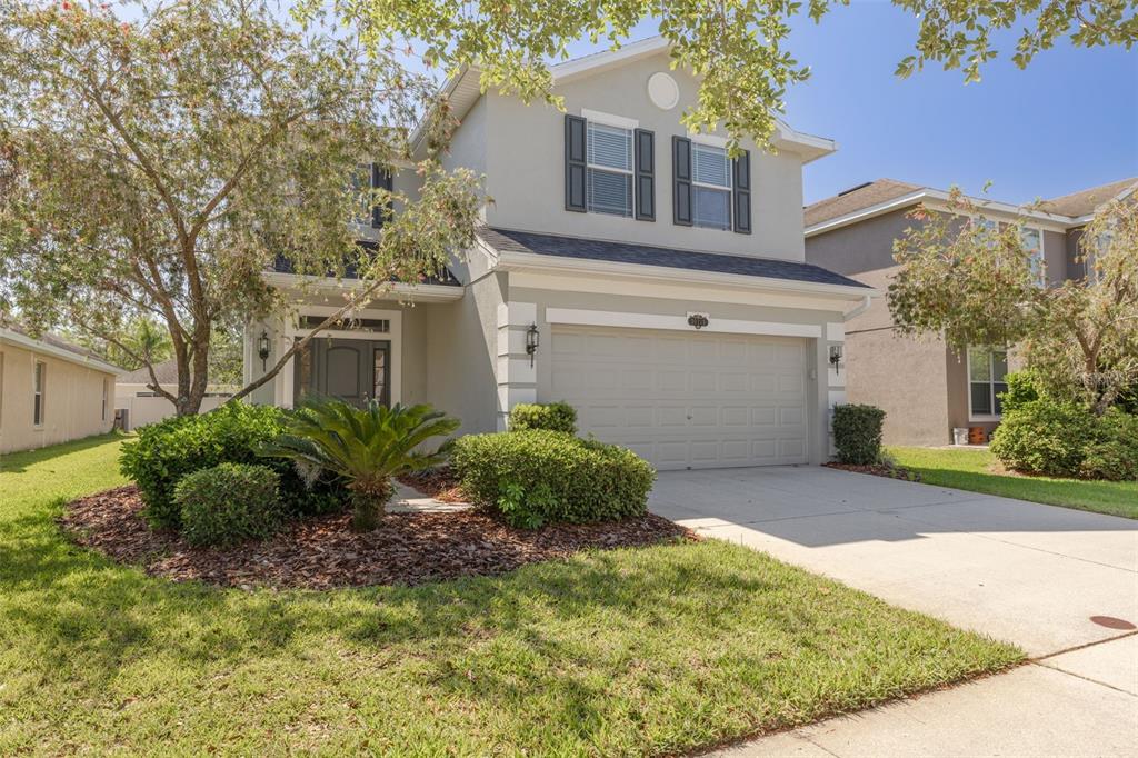 A two-story suburban house with a gray exterior, a two-car garage, and a landscaped yard — 20215 NATURES SPIRIT DRIVE, TAMPA, FL