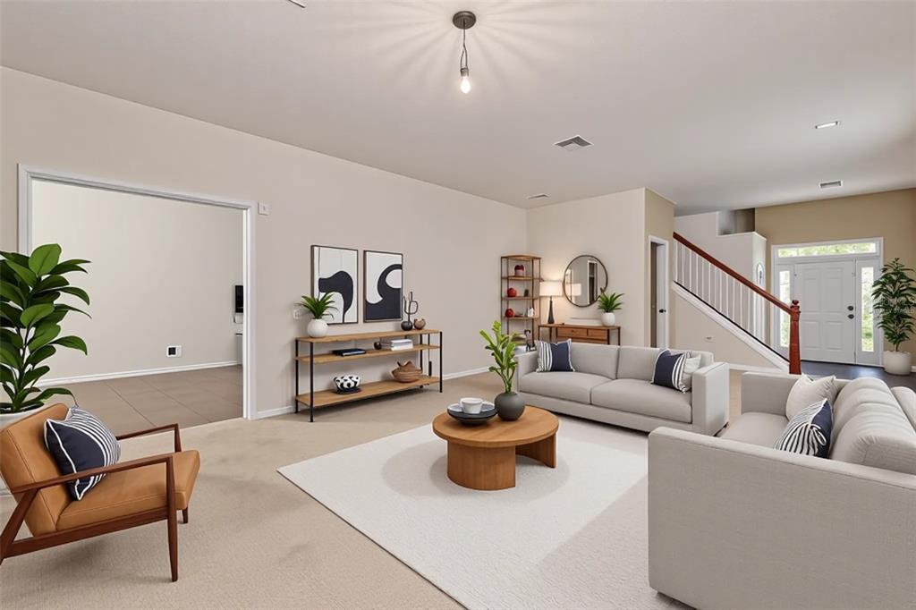 A living room features a beige sofa, a round wooden coffee table, and a staircase — 20215 NATURES SPIRIT DRIVE, TAMPA, FL