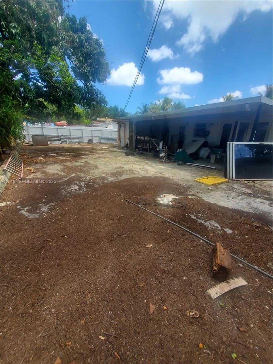 An outdoor area features a concrete patio adjacent to a building with a covered porch — 12445 SW 185th Ter, Miami FL 33177, MIAMI, FL
