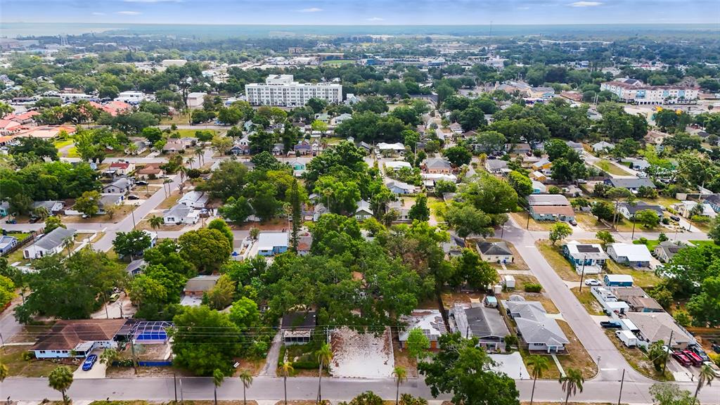 An aerial view shows a residential neighborhood with a vacant lot surrounded by houses — 1419 18TH STREET W UNIT W, BRADENTON, FL
