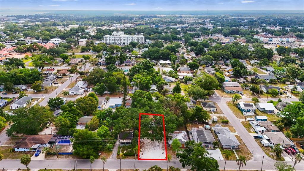 An aerial view shows a vacant, tree-covered residential lot outlined in red within a neighborhood — 1419 18TH STREET W UNIT W, BRADENTON, FL