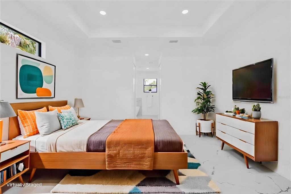 A bedroom features a wooden platform bed, a white dresser, and a geometric area rug — 1278 MILIKEN TERRACE, PORT CHARLOTTE, FL