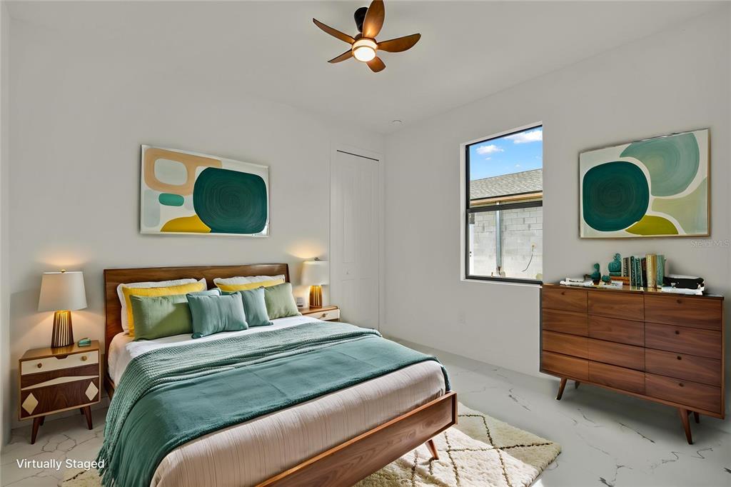 A bedroom features a wooden bed frame, a dresser, two lamps, and abstract wall art — 1278 MILIKEN TERRACE, PORT CHARLOTTE, FL