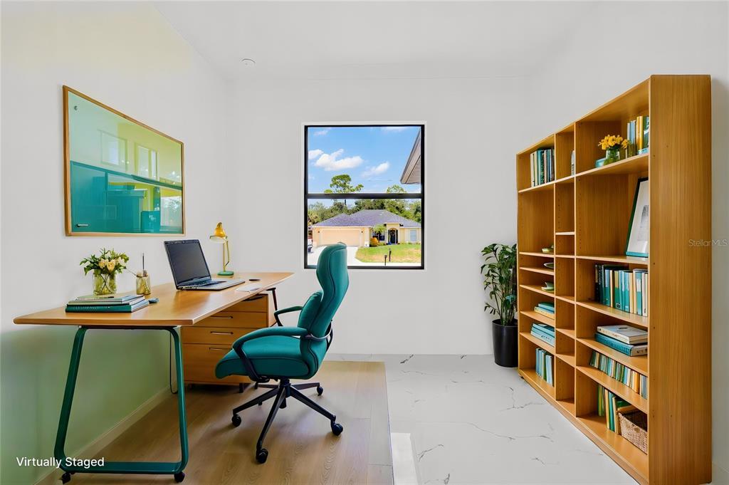 A home office features a wooden desk, a teal chair, and a large bookshelf — 1278 MILIKEN TERRACE, PORT CHARLOTTE, FL