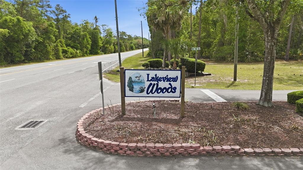 A sign for Lakeview Woods stands at the entrance of a road near a forest — 1160 NE 130TH TERRACE, SILVER SPRINGS, FL