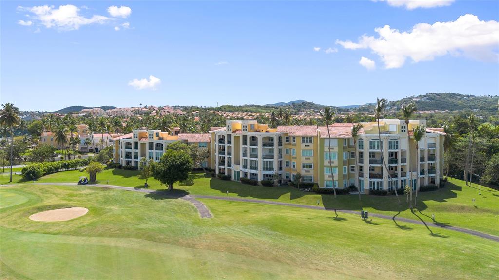 An aerial view of a multi-story apartment complex situated next to a golf course — 155 Candelero Dr. NE CANDELERO DRIVE UNIT C - 4, HUMACAO, PR