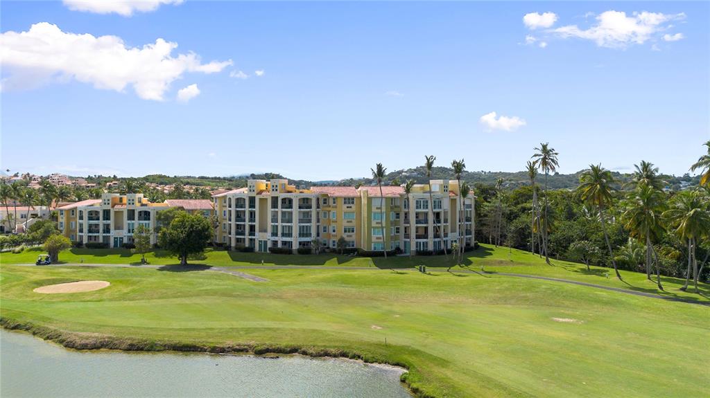 An exterior view of a multi-story apartment building overlooking a golf course and pond — 155 Candelero Dr. NE CANDELERO DRIVE UNIT C - 4, HUMACAO, PR