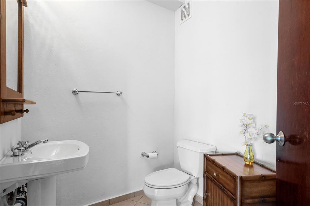 A small bathroom features a pedestal sink, a white toilet, and a wooden side cabinet — 155 Candelero Dr. NE CANDELERO DRIVE UNIT C - 4, HUMACAO, PR