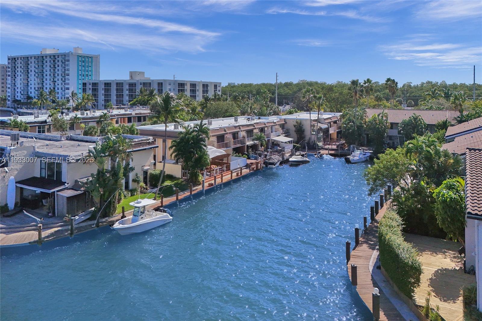 An aerial view shows a canal lined with townhouses, private docks, and moored boats — 16478 NE 27th Pl # 34, Eastern Shores FL 33160, EASTERN SHORES, FL
