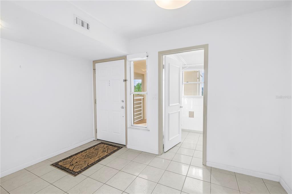 An entryway with white walls, light tile flooring, a front door, and an open doorway — 6001 BAHIA DEL MAR CIRCLE UNIT 428, ST PETERSBURG, FL