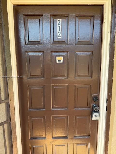 A brown, paneled front door with the number 312 and a lockbox attached — 6101 N Falls Circle Dr # 312, Lauderhill FL 33319, LAUDERHILL, FL