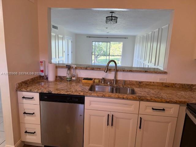 A kitchen features white cabinets, granite countertops, a stainless steel dishwasher, and a pass-through window — 6101 N Falls Circle Dr # 312, Lauderhill FL 33319, LAUDERHILL, FL