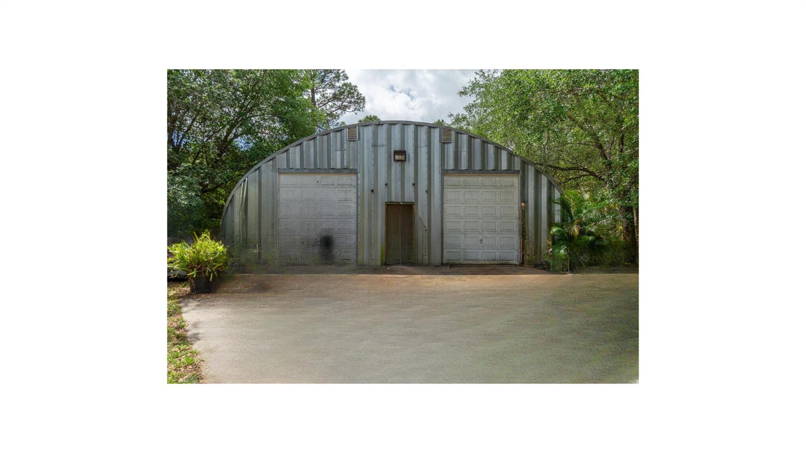 A metal Quonset hut building with two garage doors and a central entrance door — 15578 89th Place N, Loxahatchee FL 33470, LOXAHATCHEE, FL