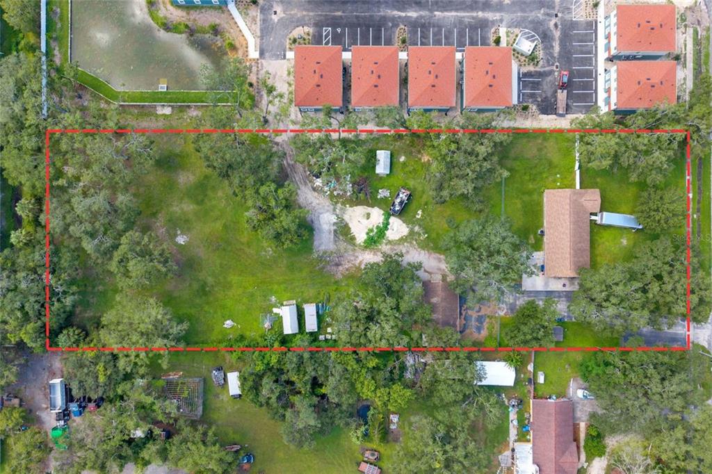 An aerial view shows a large, rectangular residential lot outlined in red with trees — 7201 E 21ST AVENUE, TAMPA, FL