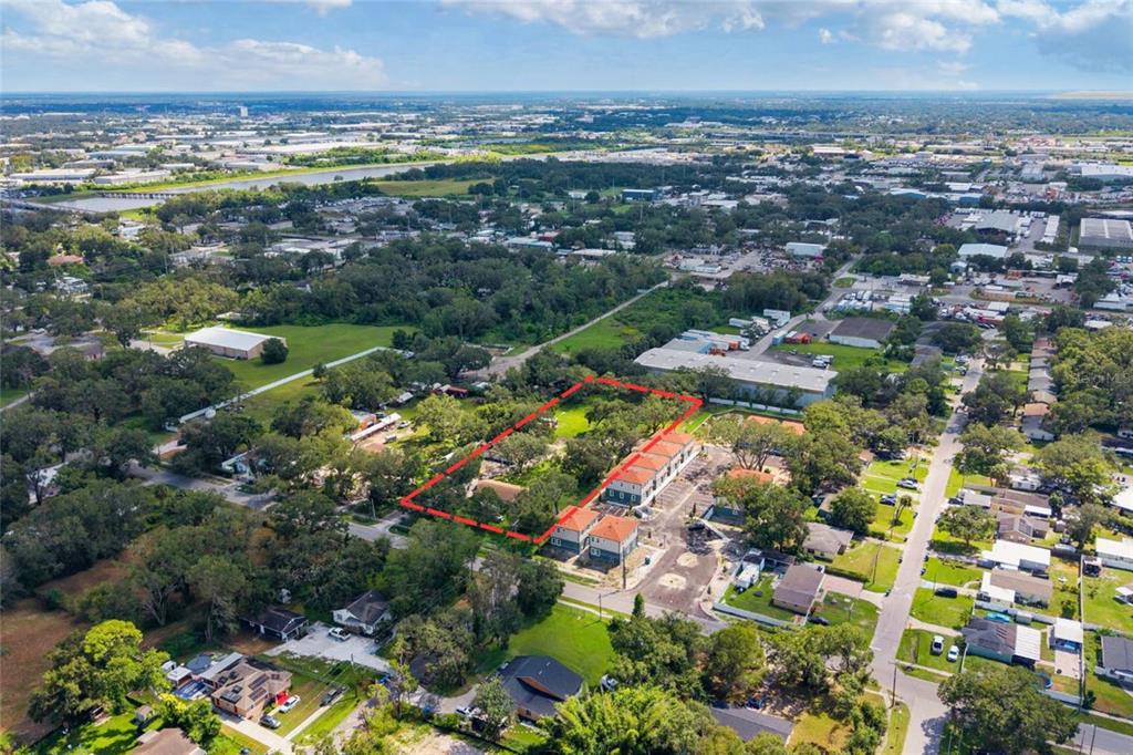 An aerial view shows a rectangular plot of land outlined in red near residential buildings — 7201 E 21ST AVENUE, TAMPA, FL