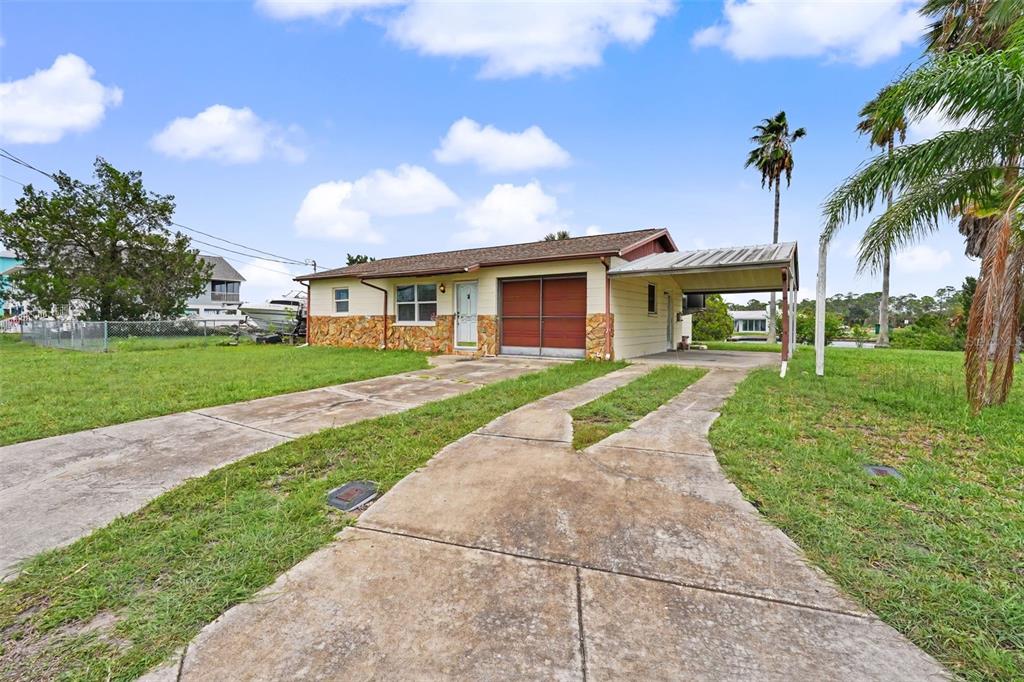 A single-story house with a stone facade, a carport, and a concrete driveway — 4093 FLAMINGO BOULEVARD, HERNANDO BEACH, FL