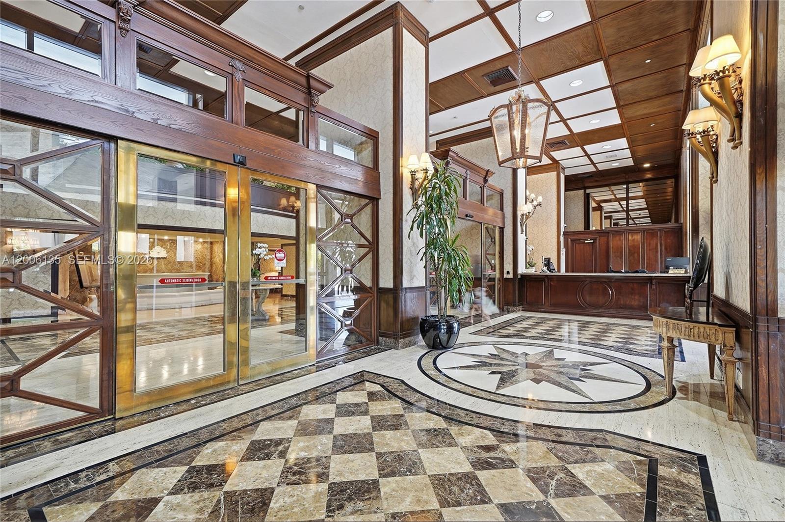 A grand lobby features a checkered marble floor, wood-paneled ceilings, and a central reception desk — 9801 Collins Ave # 14D, Bal Harbour FL 33154, BAL HARBOUR, FL