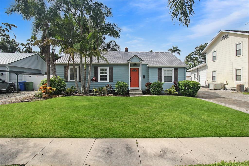 A light blue single-story house with a metal roof and a bright orange front door — 2321 18TH AVENUE W, BRADENTON, FL