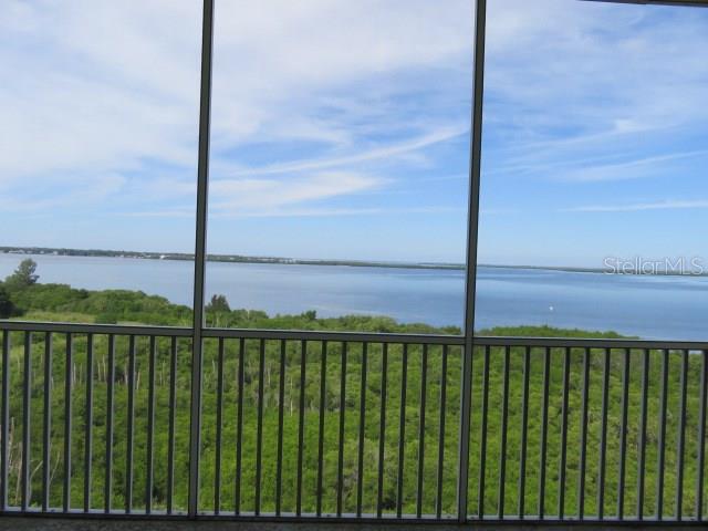 A screened-in balcony overlooks a dense green forest and a large body of water — 2625 TERRA CEIA BAY BOULEVARD UNIT 802, PALMETTO, FL