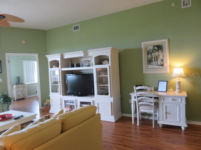 A living room features a white entertainment center, a desk, and a yellow sofa — 2625 TERRA CEIA BAY BOULEVARD UNIT 802, PALMETTO, FL
