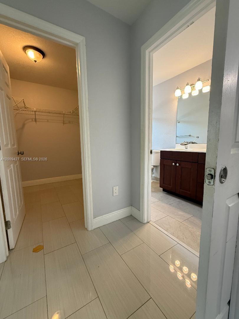 A tiled hallway leads to a walk-in closet on the left and a bathroom ahead — 2713 NW 6th St, Pompano Beach FL 33069, POMPANO BEACH, FL