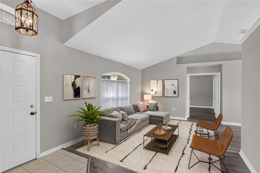 A living room features a gray sectional sofa, two leather chairs, and a coffee table — 308 CLERMONT DRIVE, KISSIMMEE, FL