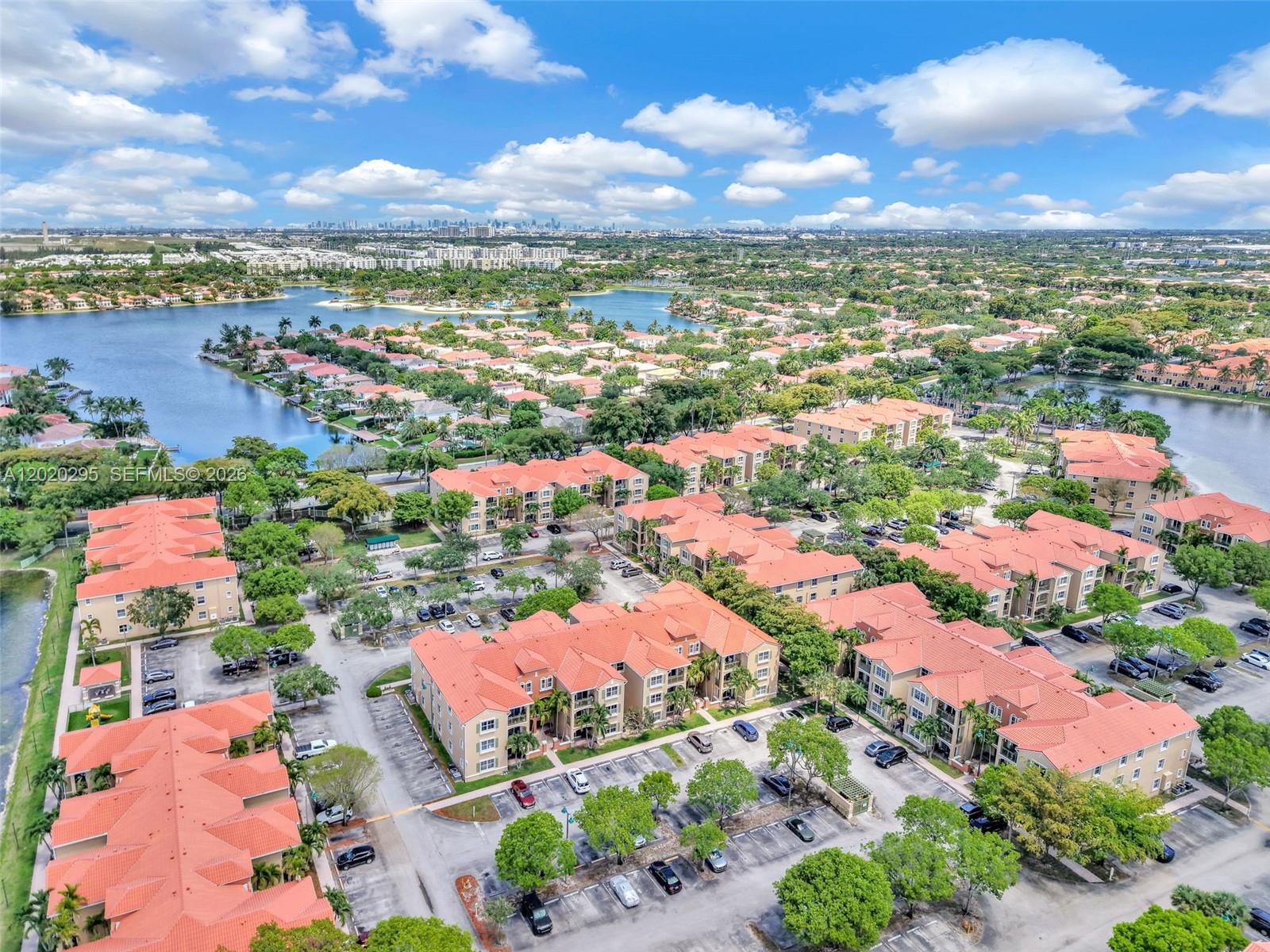 An aerial view shows multiple multi-story apartment buildings with orange roofs and surrounding parking lots — 6630 NW 114th Ave # 1538, Doral FL 33178, DORAL, FL