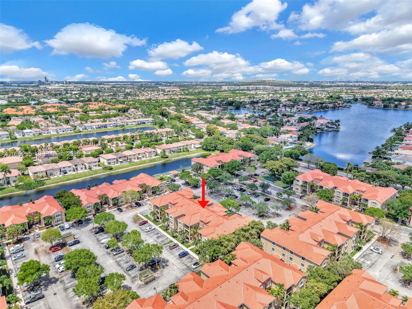 An aerial view shows multi-story residential buildings with orange tile roofs and surrounding parking lots — 6630 NW 114th Ave # 1538, Doral FL 33178, DORAL, FL
