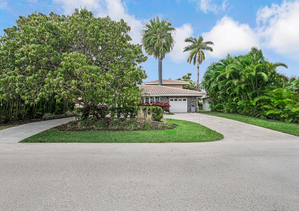 A single-story house with a stone facade, a white garage, and palm trees in front — 491 SE 16th Avenue, Pompano Beach FL 33060, POMPANO BEACH, FL