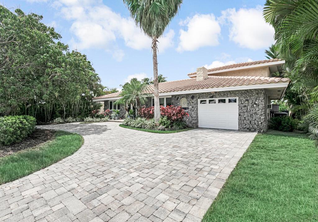 A stone-faced house with a tiled roof and a paved driveway sits among palm trees — 491 SE 16th Avenue, Pompano Beach FL 33060, POMPANO BEACH, FL