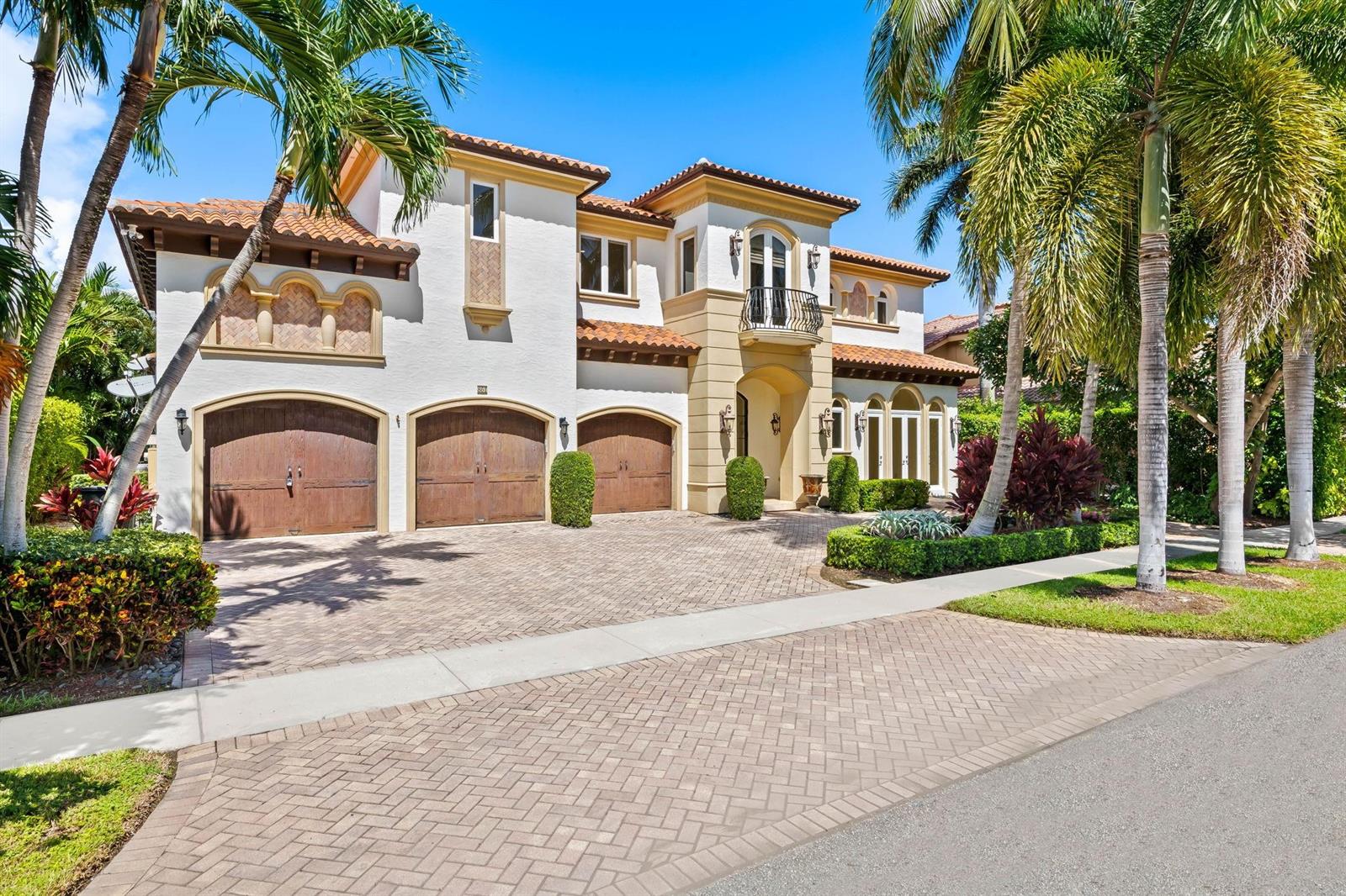 A two-story Mediterranean-style house features a three-car garage and a paved driveway — 861 Nafa Drive, Boca Raton FL 33487, BOCA RATON, FL