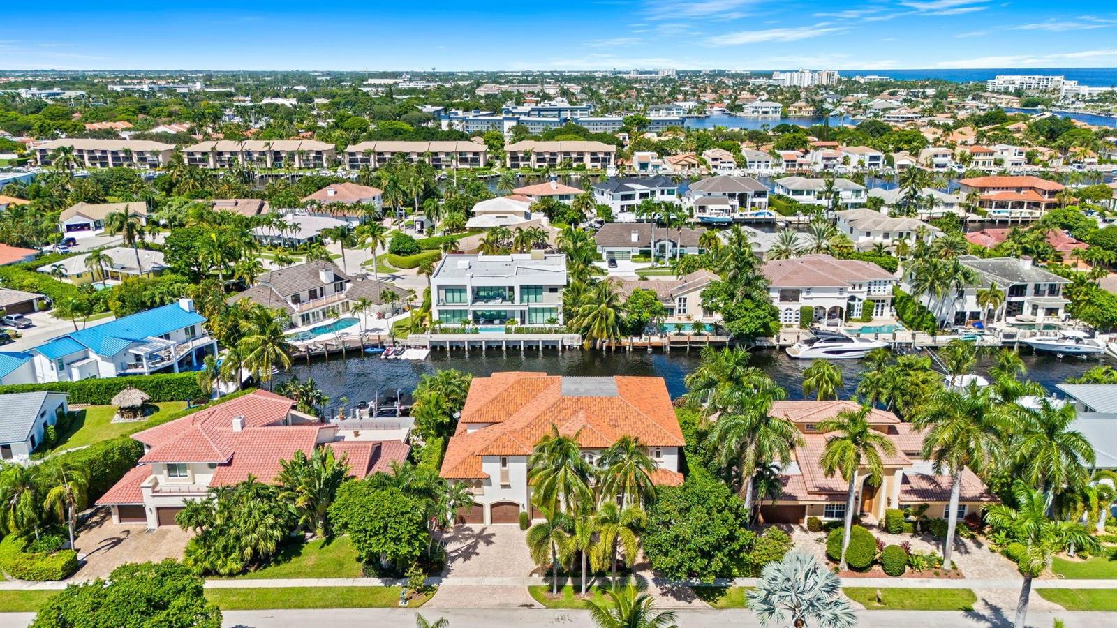 An aerial view of waterfront homes with tiled roofs, swimming pools, and private boat docks — 861 Nafa Drive, Boca Raton FL 33487, BOCA RATON, FL