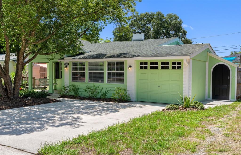 A light green single-story house with a white-trimmed garage and a concrete driveway — 641 WILKIE STREET, DUNEDIN, FL