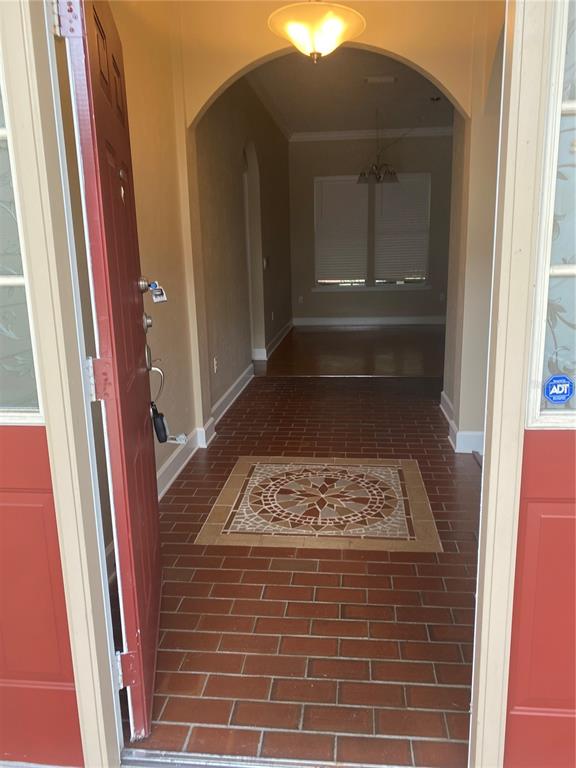 An entryway with a brick floor, a decorative tile inlay, and an arched hallway — 8389 SW 80TH PLACE, GAINESVILLE, FL