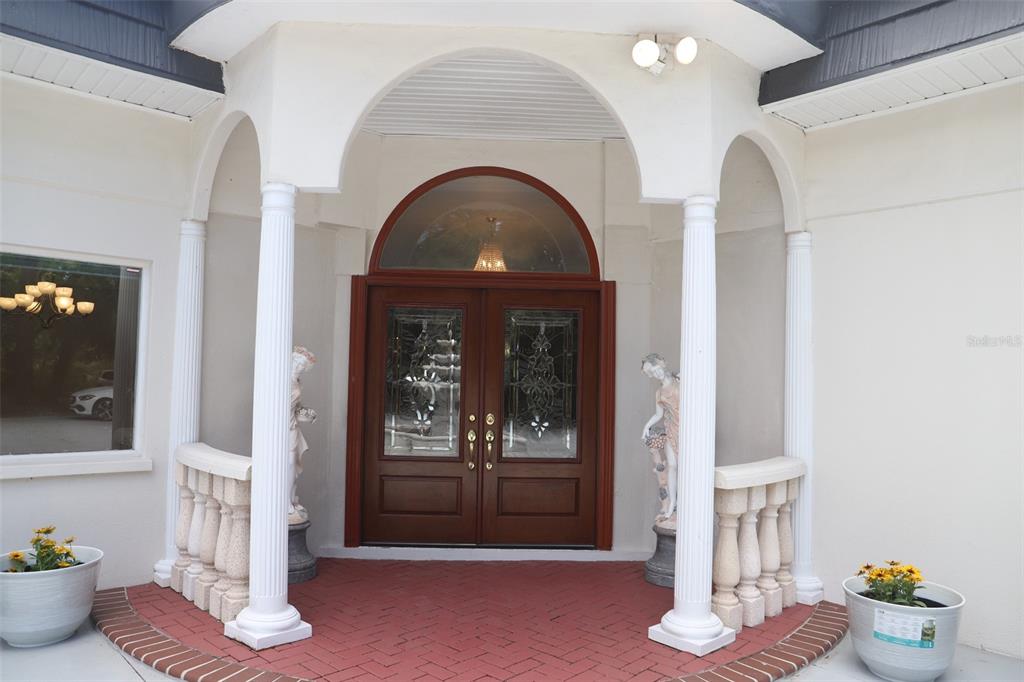 A front entrance features double wooden doors, white columns, and a red brick porch — 2810 61ST STREET, SARASOTA, FL