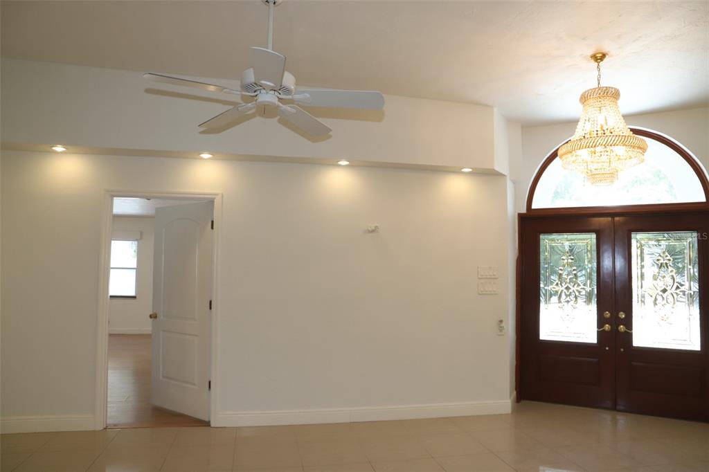 An entryway features tile flooring, a crystal chandelier, a ceiling fan, and a double front door — 2810 61ST STREET, SARASOTA, FL