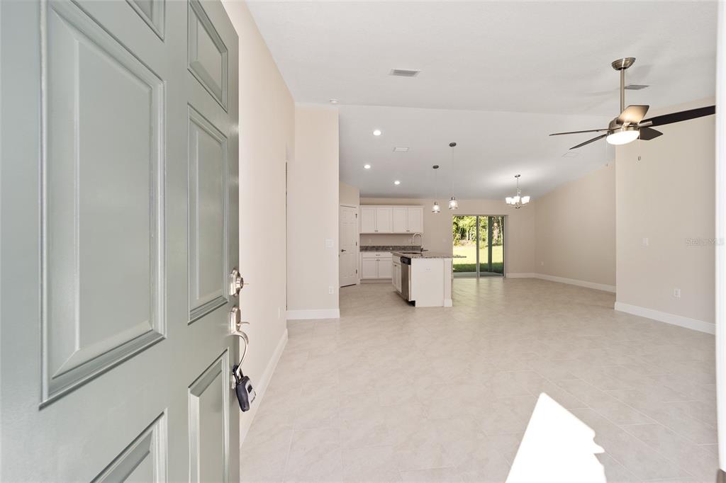 An open-concept living area with tile flooring, a kitchen island, and a ceiling fan — 2398 W DEVON DRIVE, CITRUS SPRINGS, FL