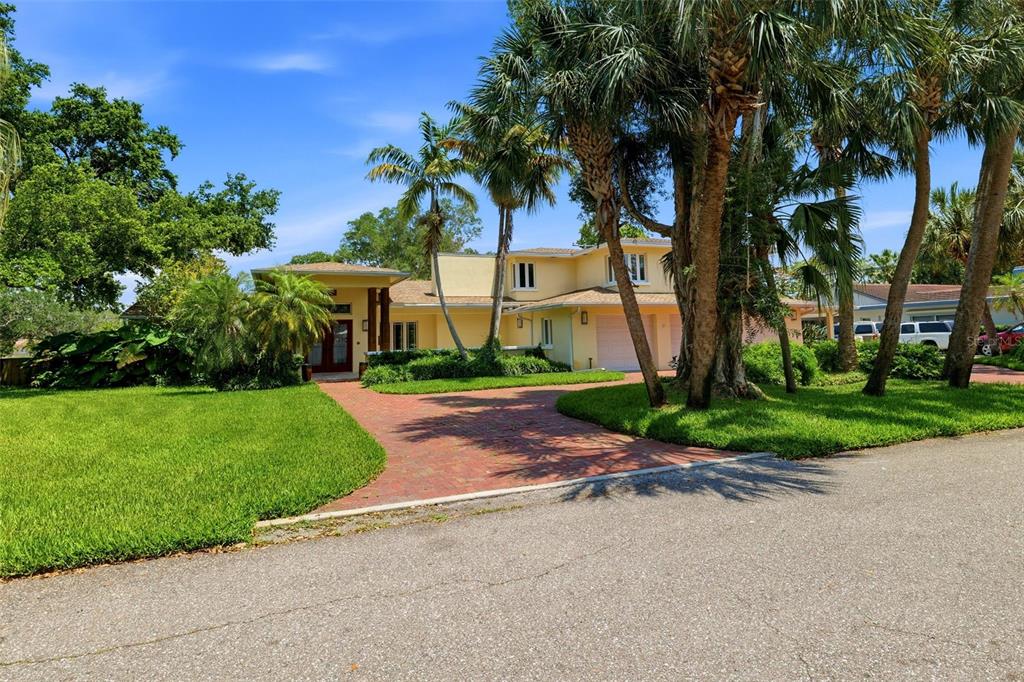 A two-story yellow house with a brick driveway and palm trees in the front yard — 6000 2ND STREET S, ST PETERSBURG, FL