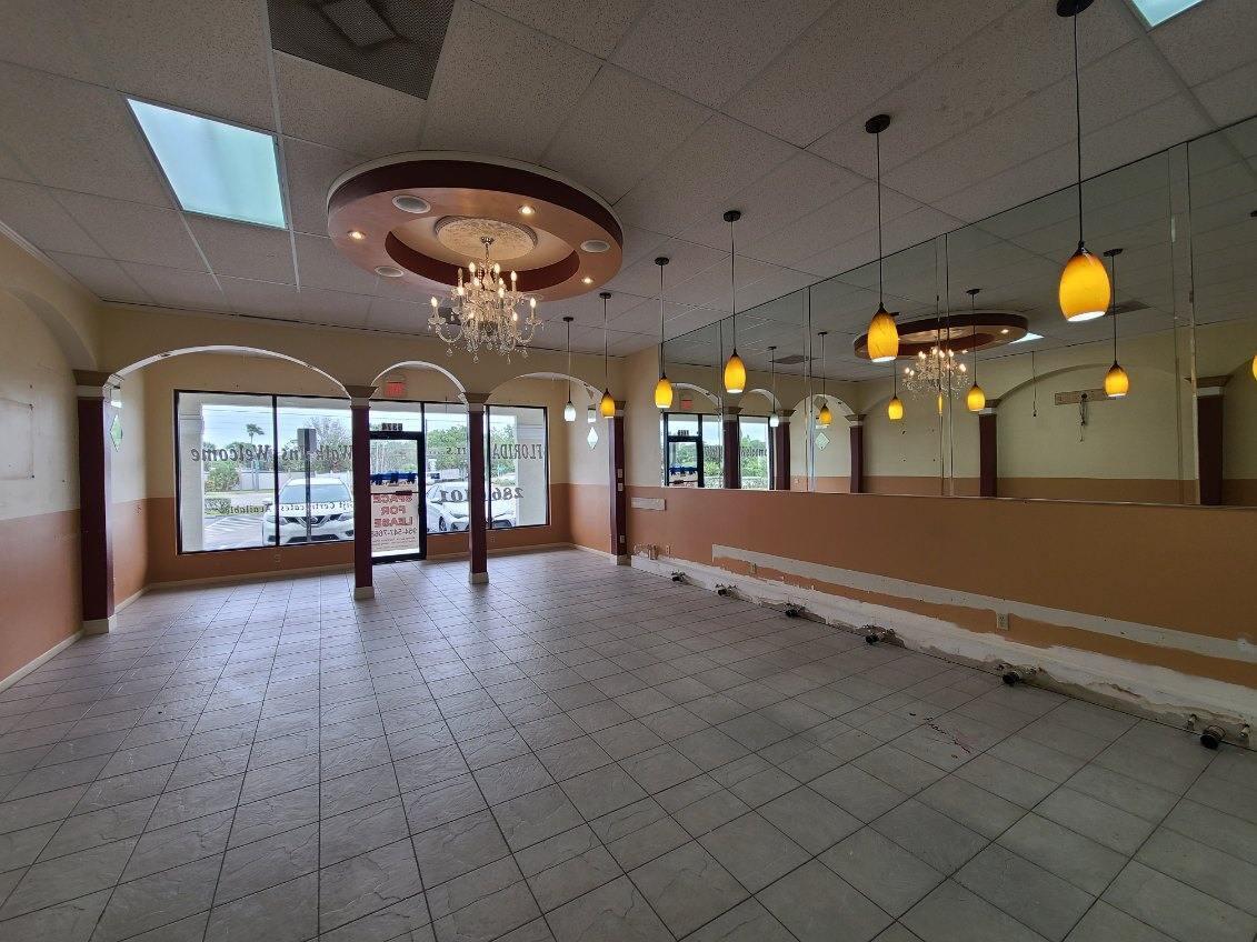 An empty commercial space features tile flooring, mirrored walls, pendant lighting, and a decorative ceiling medallion — 6374 SE Federal Highway # 6374, Stuart FL 34997, STUART, FL