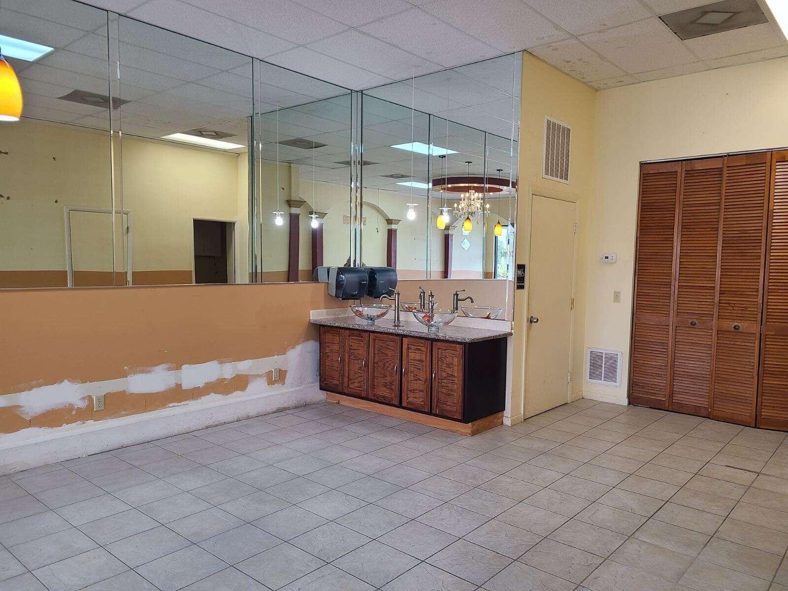 A commercial restroom area features a vanity with two glass sinks, mirrors, and tiled flooring — 6374 SE Federal Highway # 6374, Stuart FL 34997, STUART, FL