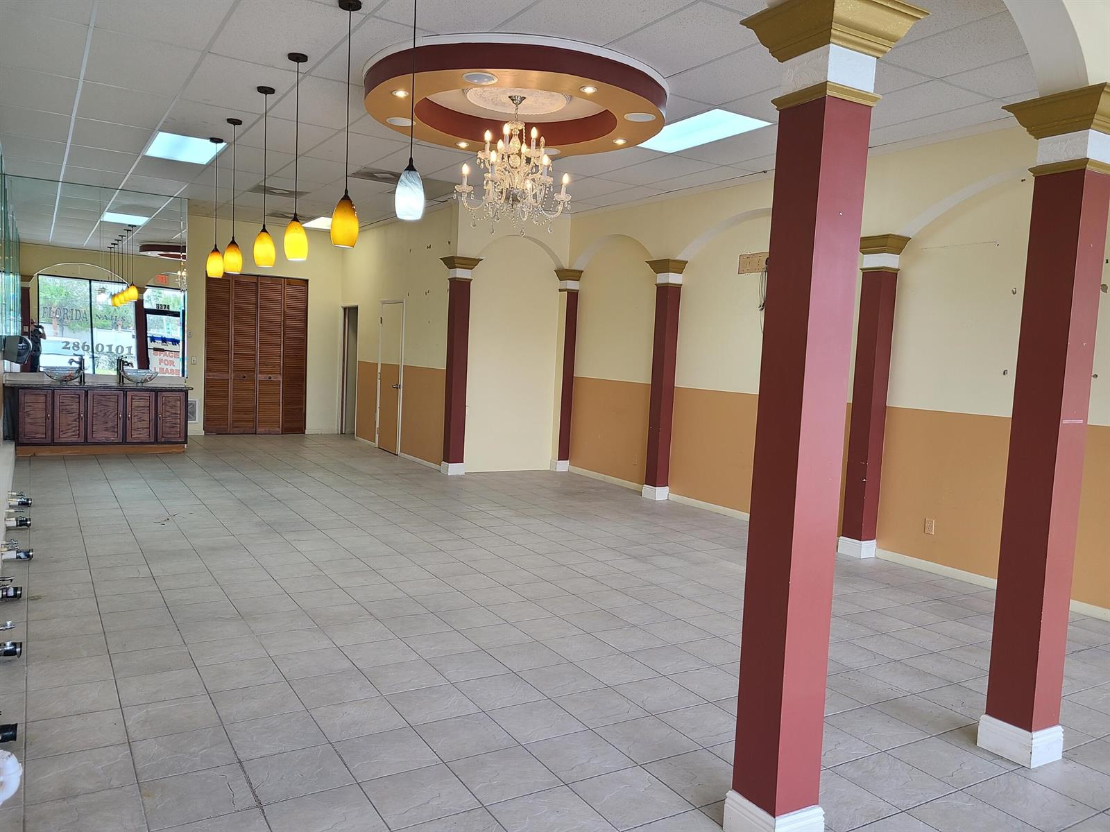 An empty commercial space features tiled floors, decorative columns, pendant lighting, and a crystal chandelier — 6374 SE Federal Highway # 6374, Stuart FL 34997, STUART, FL